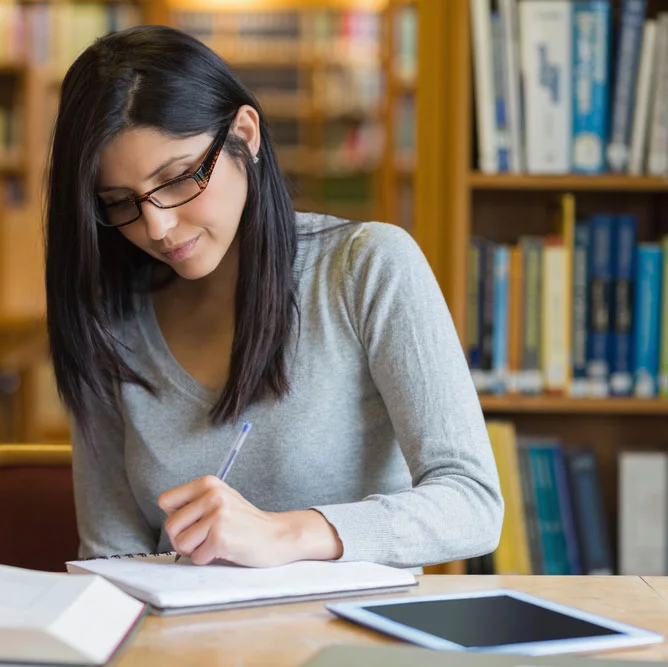 ARE Candidate studying NCARB's Practice Management exam materials at desk