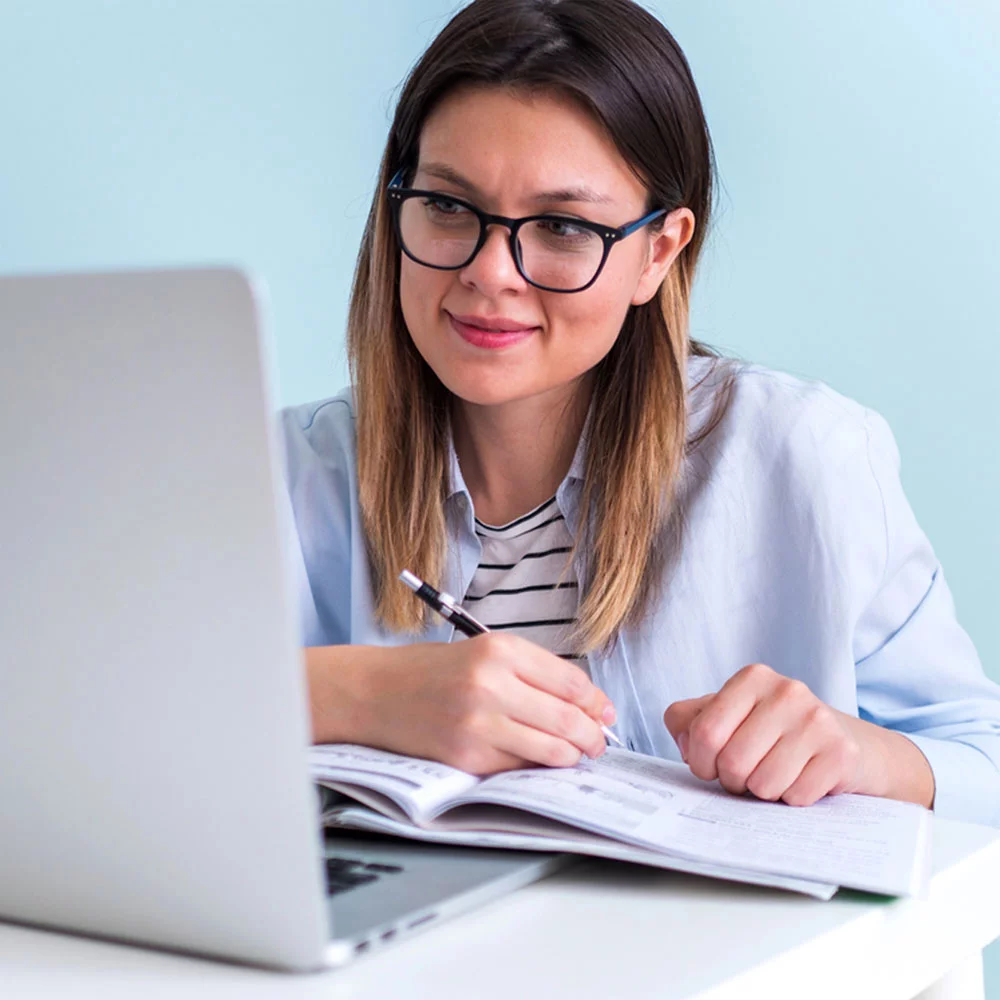 ARE Candidate studying building codes for NCARB's architect exam study materials at desk